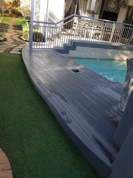A timber deck with balustrade beside a pool