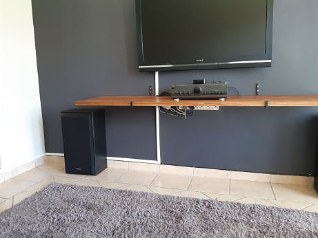 A shelf and TV hung, with the cables in trunking